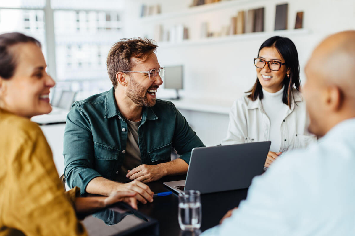 Diverse group of business people in a meeting smiling.